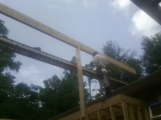 Carpenter setting a ridge beam over a new addition frame — Ice Dam Removal by Roofing Brothers in Ambler