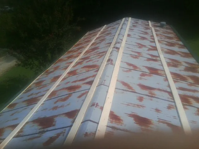 Rusted metal roof panels with new wood purlins before replacement — Storm Damage Roof Repair in Ambler by Roofing Brothers