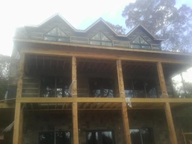 Dormers and porch framing on a large log home under construction — Roof Coating work by our crew in Ambler