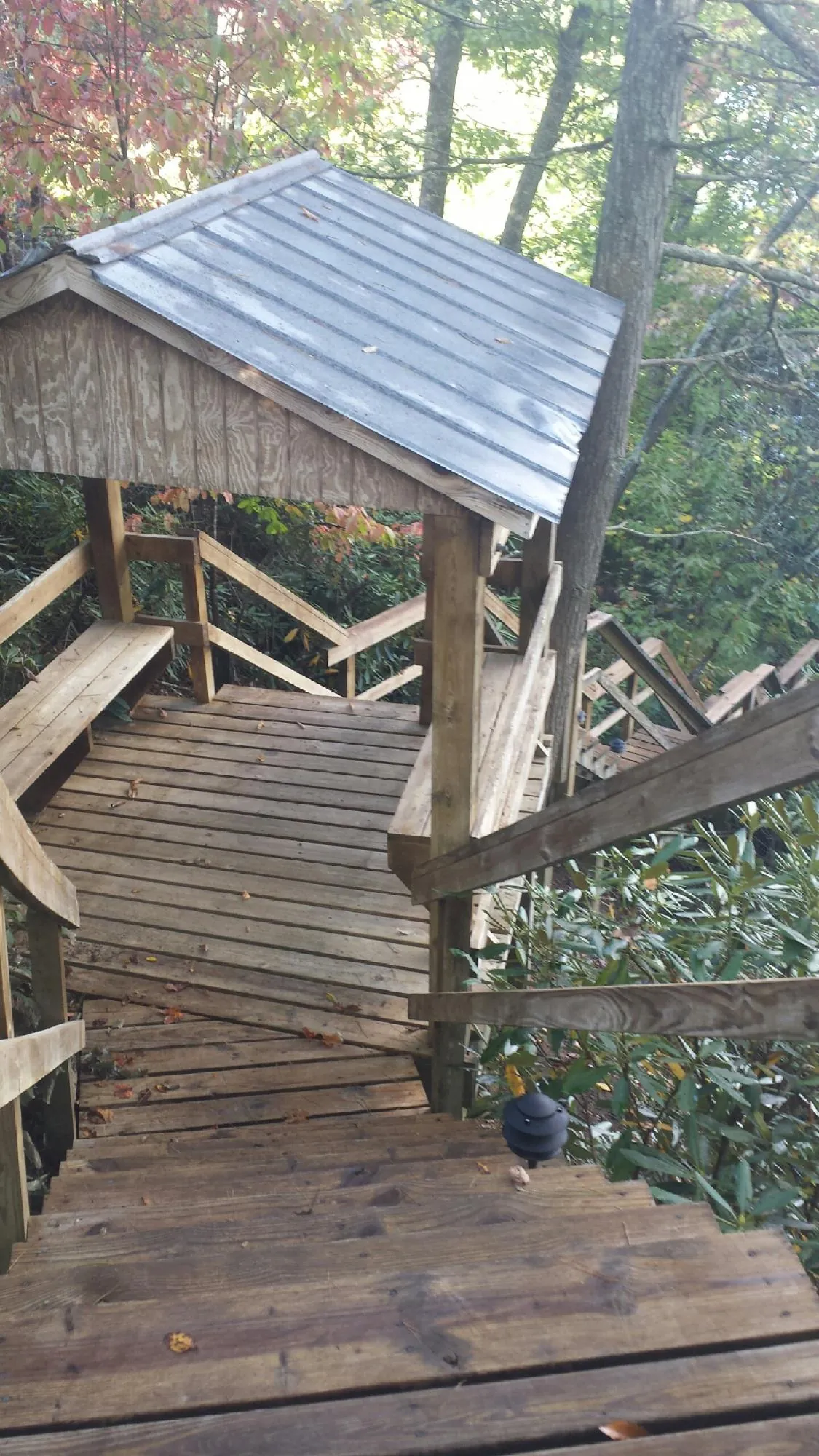 Metal roofed shelter over wooden steps on a wooded walkway — Skylight Repair & Installation work by our crew in Ambler
