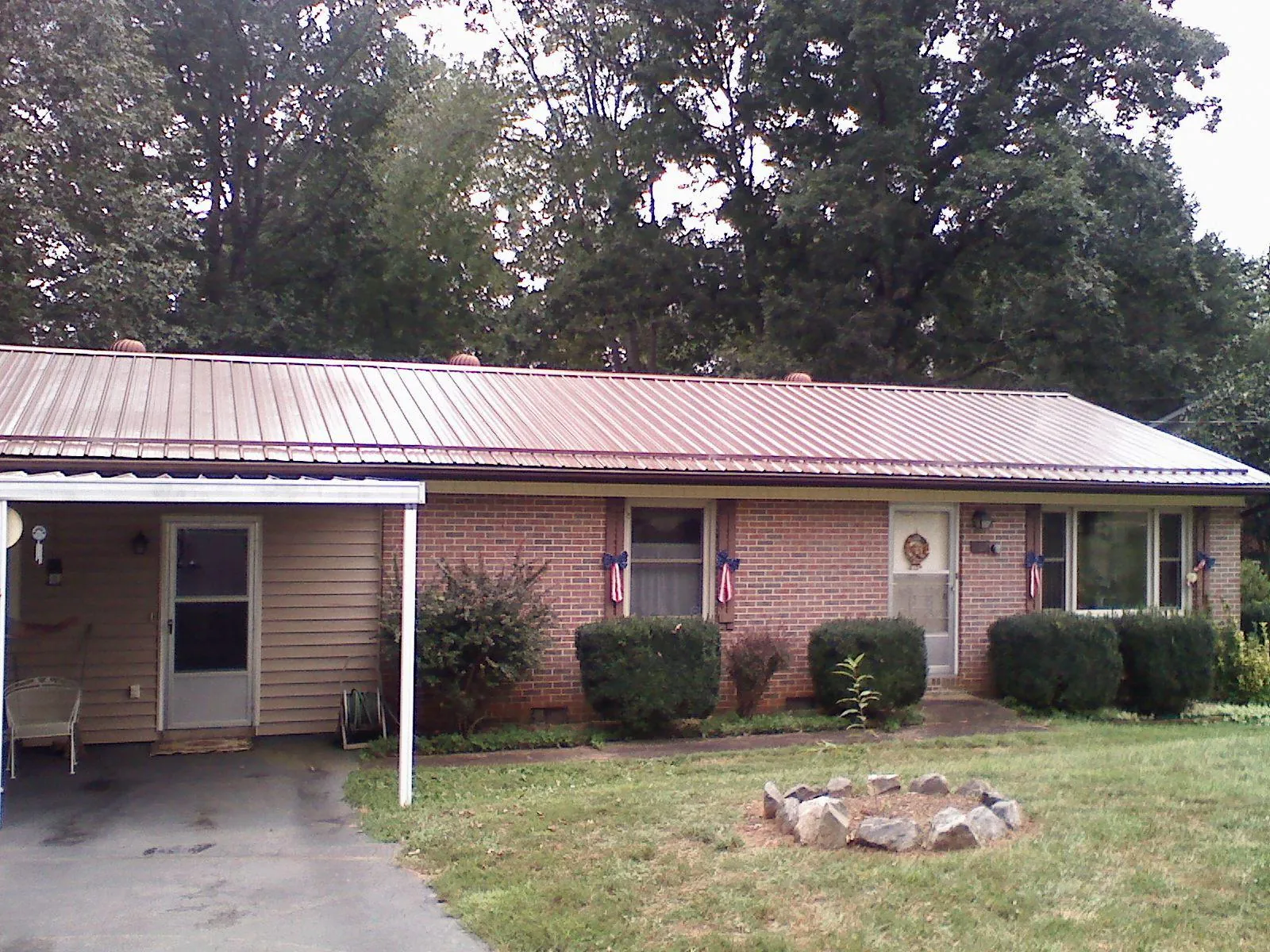 Bronze metal roof and carport on a brick ranch home — Roof Repair work by our crew in Ambler